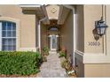Inviting front entryway with stone walkway, manicured greenery, and a decorative front door at 10105 Holly Berry Dr, Weeki Wachee, FL 34613