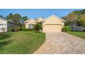 Inviting curb appeal of a well-maintained single-Gathering home with lush green lawn and brick driveway at 10105 Holly Berry Dr, Weeki Wachee, FL 34613