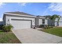Well-kept home with a two-car garage, fresh landscaping, and a manicured lawn at 13359 Golden Lime Ave, Spring Hill, FL 34609