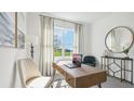 Bright study featuring a large window, a stylish desk and seating area at 17468 Whiskey Creek Trl, Parrish, FL 34219