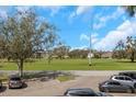 Building exterior with green recreational space, mature landscaping, and designated parking at 2403 Finlandia Ln # 27, Clearwater, FL 33763