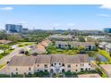 Scenic aerial view of townhomes with a beautiful pond and cityscape backdrop at 2462 Kingfisher Ln # J203, Clearwater, FL 33762