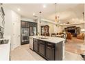 Modern kitchen with stainless steel appliances, central island, and open floor plan to the living and dining areas at 25325 Welsh Poppy Way, Land O Lakes, FL 34639