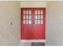 Close-up of the double front doors with glass panes and a decorative welcome mat at 2717 Warwick Ter, Palm Harbor, FL 34685