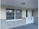 Close-up of the front porch, showcasing a secure front door and large window at 3641 Dickens Dr, Holiday, FL 34691
