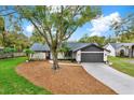 Charming single-story home with a well-manicured lawn and a driveway leading to an attached garage at 3944 Sprucewood Pl, Land O Lakes, FL 34639