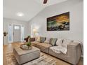 Inviting living room featuring neutral walls, plank flooring, a cozy sofa, and a striking coastal art piece at 3944 Sprucewood Pl, Land O Lakes, FL 34639