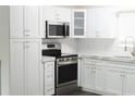 Modern kitchen featuring white cabinetry, subway tile backsplash, stainless steel appliances, and stone countertops at 4036 Cortez Dr # A, Tampa, FL 33614