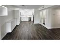Open-concept living and kitchen area with wood floors and a bright, white kitchen and french doors at 4036 Cortez Dr # A, Tampa, FL 33614