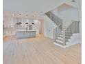 Open concept living area featuring hardwood floors, white cabinets, and a staircase at 418 W Frances Ave # 2, Tampa, FL 33602