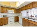 Functional kitchen with oak cabinets, white appliances, and a view into an adjacent room at 438 Mariner Dr, Tarpon Springs, FL 34689