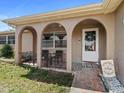 Inviting front porch features arched entryways, charming decor, and outdoor seating for relaxing in style at 5117 School Rd, New Port Richey, FL 34653