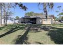 Spacious backyard with grass, screened-in porch, and a white fence at 5155 Kenmore St, Spring Hill, FL 34608