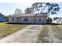 Exterior view of home with a concrete driveway and a well maintained lawn at 5155 Kenmore St, Spring Hill, FL 34608