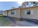 Close up of the side and front of a house with a concrete sidewalk and white shutters at 5155 Kenmore St, Spring Hill, FL 34608
