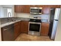 Well-lit kitchen features stainless steel appliances and light brown cabinets at 6011 Skydale Way # 101, Riverview, FL 33578