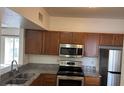 Modern kitchen with stainless steel appliances, granite countertops, and wood cabinetry at 6011 Skydale Way # 101, Riverview, FL 33578