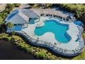 Aerial view of community pool area surrounded by lounge chairs, lush landscape, and a cabana at 6011 Skydale Way # 101, Riverview, FL 33578