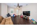 Bright living room with dark wood floors, a ceiling fan, and comfortable furniture, creating a cozy atmosphere at 9411 Cavendish Dr # 107, Tampa, FL 33626