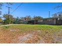 Expansive front yard leading to a single-story home with a charming screened-in front porch at 200 W Louisiana Ave, Tampa, FL 33603