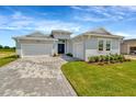 Charming single-story home with a paved driveway, well-manicured lawn, and inviting double-door entryway at 10714 Torchwood Sea Way, San Antonio, FL 33576