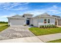 Charming single-story home with a paved driveway, well-manicured lawn, and inviting double-door entryway at 10714 Torchwood Sea Way, San Antonio, FL 33576
