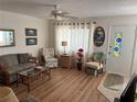 Comfortable living room features a ceiling fan, sofas, chairs, and view of the entry door at 11251 80Th Ave # 210, Seminole, FL 33772