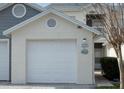 Garage of a two-story home featuring carriage doors, decorative accents, and a well-maintained exterior at 11680 Shipwatch Dr # 1454, Largo, FL 33774