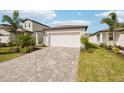 A one-story home featuring an attached two-car garage, a brick driveway, and simple landscaping at 129 Whiteland Bnd, Nokomis, FL 34275