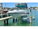 Boat on lift featuring covered top and sleek design at 1616 Sand Key Estates Ct, Clearwater Beach, FL 33767