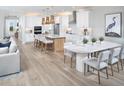 Open-concept living space features a kitchen island, dining area, and hardwood floors at 18585 Watercolor Ave, Venice, FL 34293