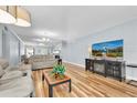 Spacious living room featuring wood floors, neutral tones, and a large TV at 2170 Americus S Blvd # 6, Clearwater, FL 33763