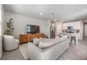 Spacious living area with tile flooring, a comfortable sofa, and modern decor leading into the kitchen at 2710 Chestnut Creek Pl, Brandon, FL 33510