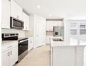 Contemporary kitchen with stainless steel appliances, white cabinets, and a stylish island for food preparation at 31640 Malbec Dr, Brooksville, FL 34602