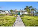 Inviting single-story home featuring a lush lawn and neat landscaping under a clear sky at 343 37Th Ne Ave, St Petersburg, FL 33704