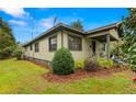 Attractive home exterior with manicured shrubs, mulched flowerbeds, and covered front porch at 37713 Florida Ave, Dade City, FL 33525