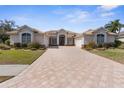 Charming single-story home with a tile roof, manicured lawn, and a spacious brick-paved driveway at 5021 Championship Cup Ln, Spring Hill, FL 34609