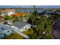 Backyard view of a single-story home with a fenced yard and lush landscaping near a beautiful lake at 715 Virginia Ave, Tarpon Springs, FL 34689