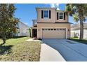 Two-story home featuring a two-car garage and manicured front yard at 7525 Forest Mere Dr, Riverview, FL 33578