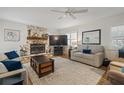 Cozy living room featuring a stone fireplace, plush seating, and a ceiling fan for added comfort at 906 Alpine Dr, Brandon, FL 33510