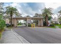 Community entrance with gate house, mature landscaping, and prominent signage at 9808 62Nd N Ter # 9808, St Petersburg, FL 33708