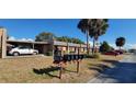Condo exterior featuring multiple mailboxes, a covered carport, and palm trees at 11204 Pembridge Ct # 5, Port Richey, FL 34668