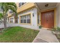Inviting townhouse entrance with a warm-toned door, manicured lawn, and stylish architectural details at 111 N Albany Ave # 3, Tampa, FL 33606