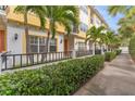 Beautiful townhouse exterior featuring vibrant yellow accents, lush green landscaping, and a charming pathway at 111 N Albany Ave # 3, Tampa, FL 33606