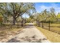 Long driveway leading to the property, framed by an ornate iron security gate at 1122 S Mulrennan Rd, Valrico, FL 33594