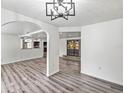 Open-concept living area with arched entryways and gray wood-look floors at 1122 S Mulrennan Rd, Valrico, FL 33594