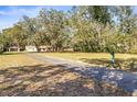 Expansive view of the property, showcasing the detached garage and mature trees at 1122 S Mulrennan Rd, Valrico, FL 33594
