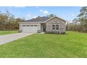 Charming single-story home with stone accents, well-maintained lawn and a two car garage at 13065 Tinamou Ave, Weeki Wachee, FL 34614