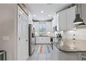 Modern kitchen features white cabinets, granite countertops, stainless steel appliances, and subway tile backsplash at 1308 Syrah Dr, Oldsmar, FL 34677
