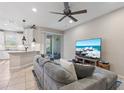 Comfortable living room boasts a sectional sofa, ceiling fan, and sliding glass doors to the outdoor patio at 1308 Syrah Dr, Oldsmar, FL 34677